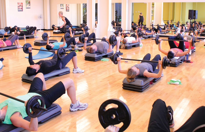 MAC-BodyPump-Group-Fitness-Class Group fitness class bench pressing barbells