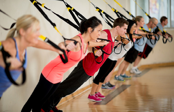 TRX-Suspension-Training A group fitness class holds pose on TRX ropes.