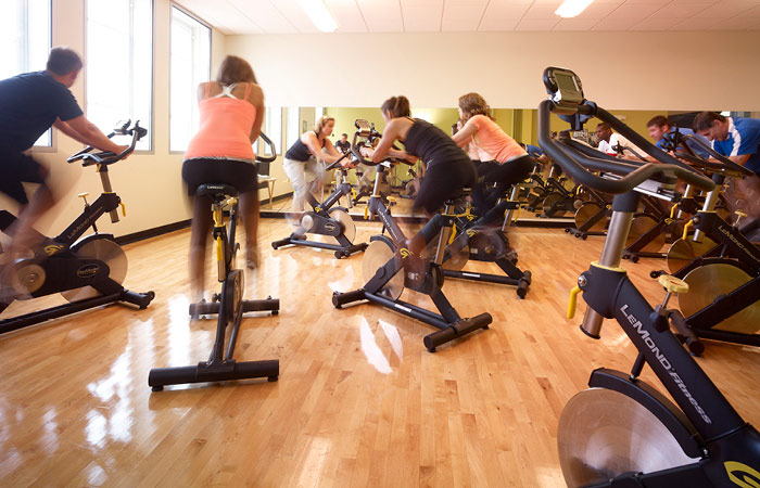 Men and women cycling during a Magnuson Athletic Club group fitness class.