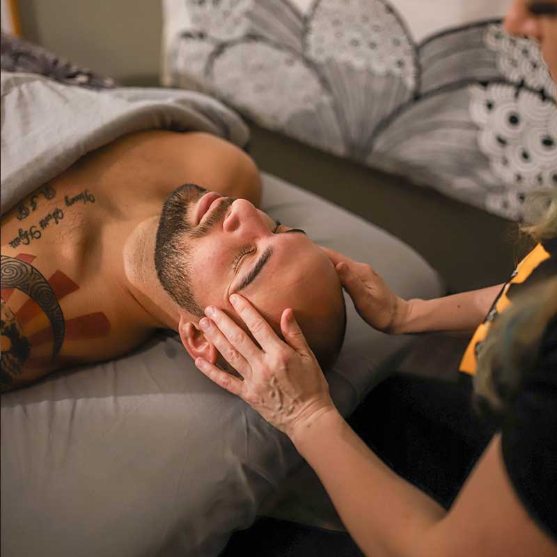 A man receives a forehead massage in the Massage Lounge at Magnuson Athletic Club